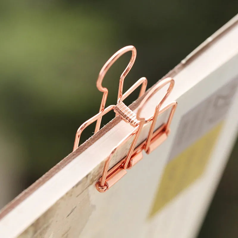 Rose gold metal binder set showing large and small folders with metal rings for tickets and papers.