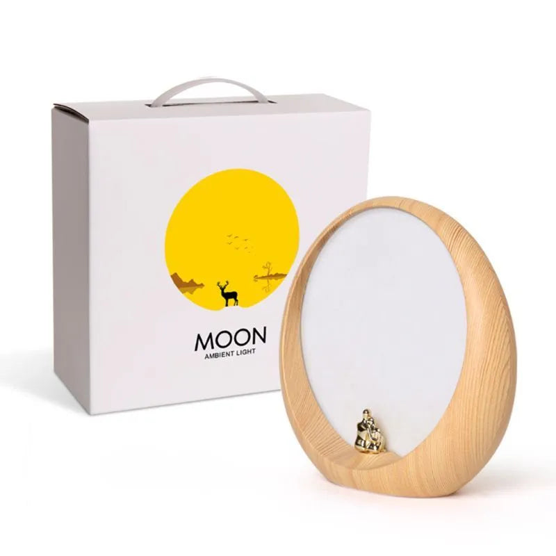 Creative hidden moon light LED table lamp with ABS shade in blue colour on a bedside table