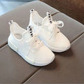 Mesh girls' primary school sneakers in white with rubber sole and front tie closure on a plain background