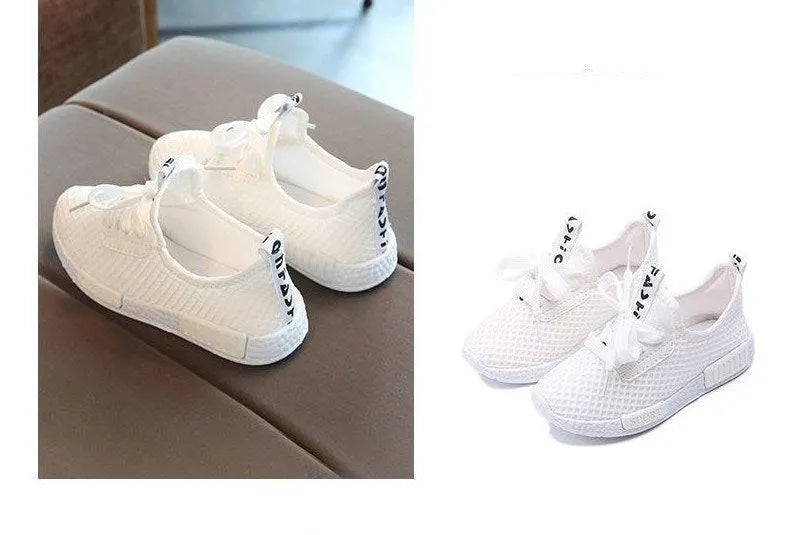 Mesh girls' primary school sneakers in white with rubber sole and front tie closure on a plain background
