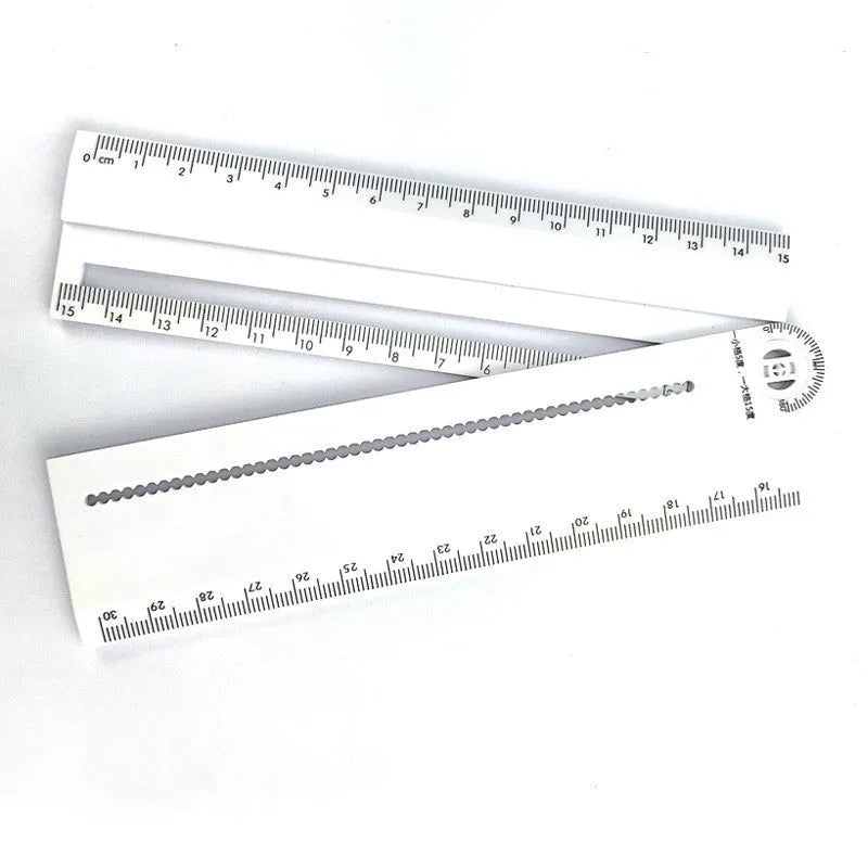 White plastic multi-function ruler measuring 30cm in length.