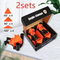 Set of four white plastic 90-degree right-angle clamps for picture frames on a workbench.