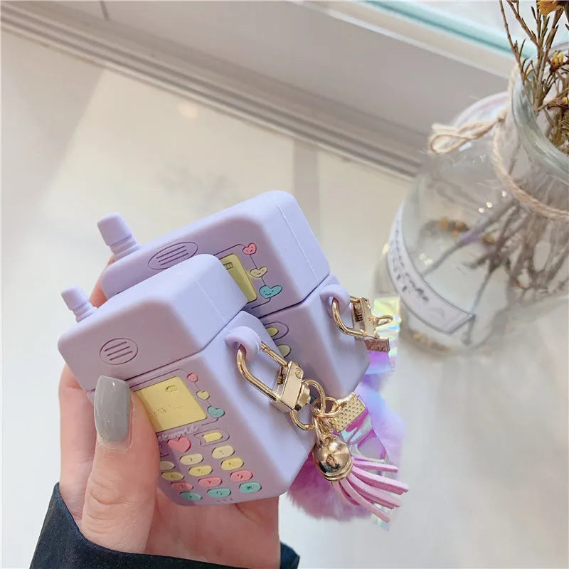 Purple silicone protective case for Apple AirPods with a small white fur ball pendant attached.