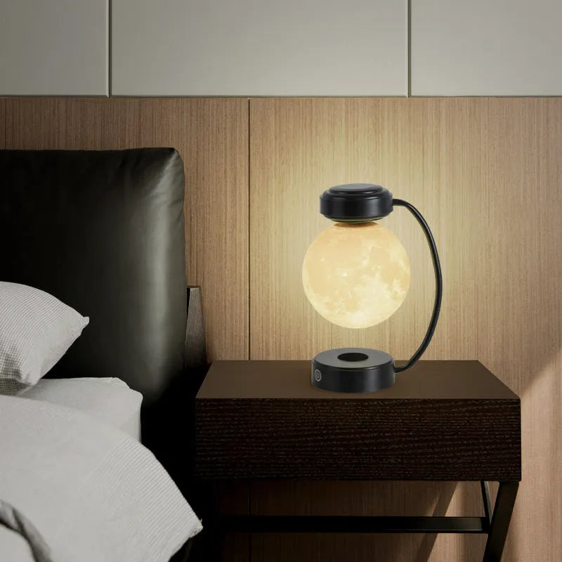 Black magnetic levitation moon lamp floating above its base with warm golden light.