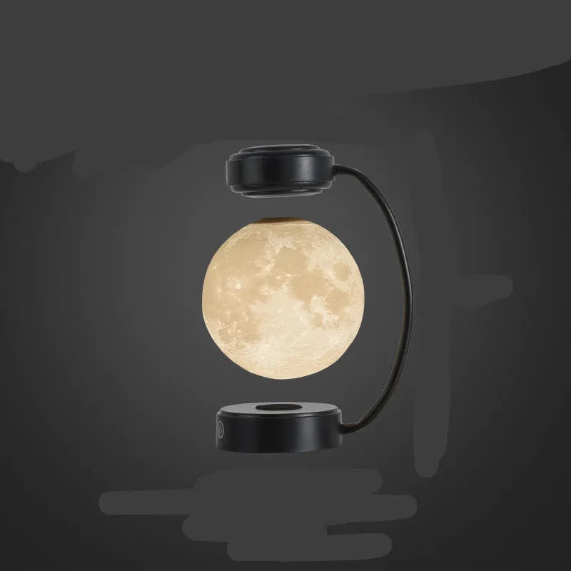 Black magnetic levitation moon lamp floating above its base with warm golden light.