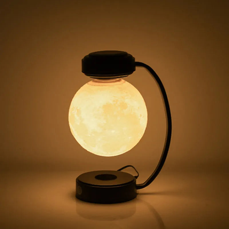 Black magnetic levitation moon lamp floating above its base with warm golden light.