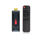 Small black Android TV set-top box dongle with remote control, power supply, and HDMI cable.