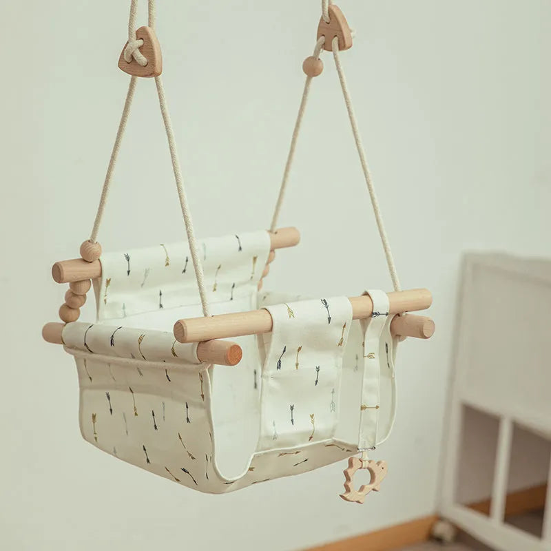 Cotton canvas baby swing chair with wooden seat hanging indoors