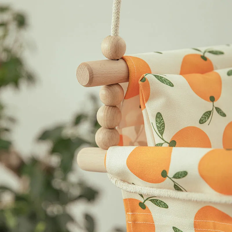 Cotton canvas baby swing chair with wooden seat hanging indoors