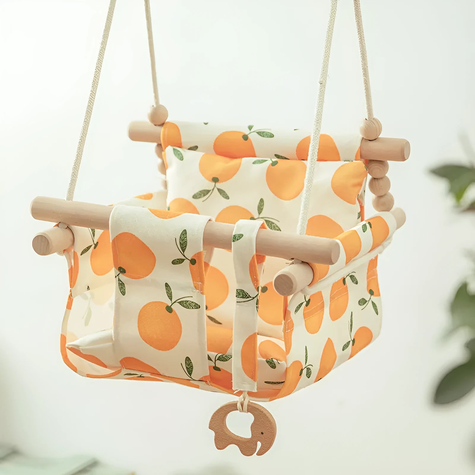 Cotton canvas baby swing chair with wooden seat hanging indoors