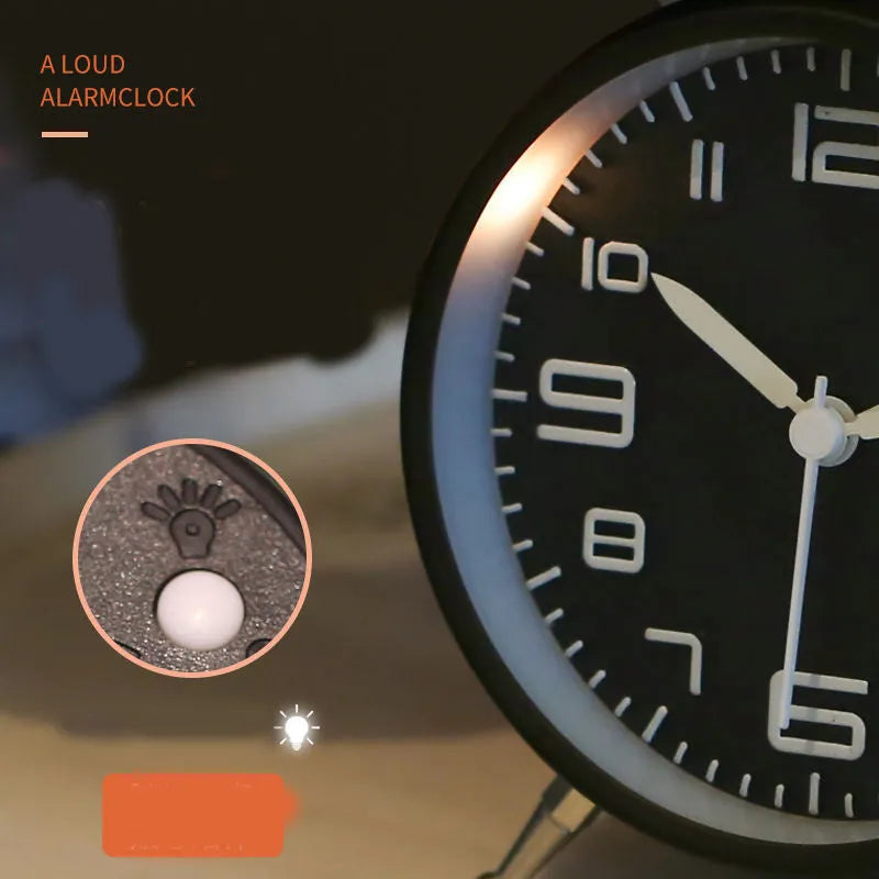 Large black metal alarm clock with luminous display and silent sweep movement on a bedside table