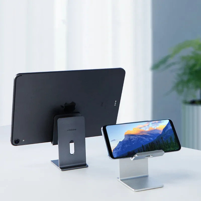 Dark Space Gray alloy desktop mobile phone and tablet holder on a wooden desk.