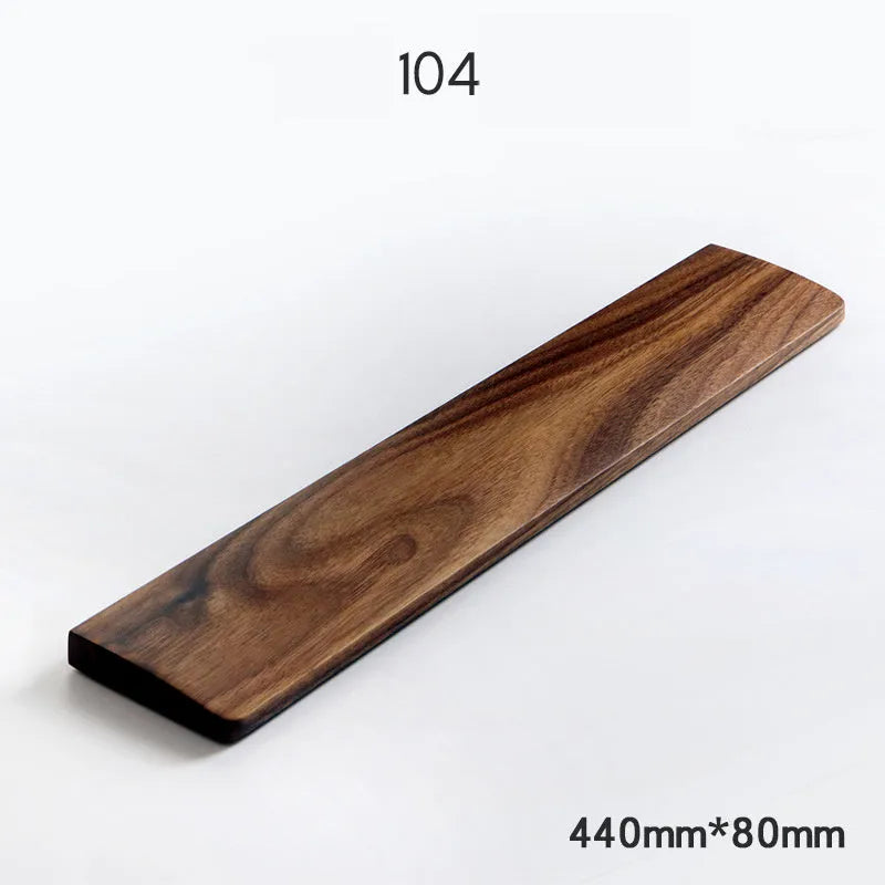 Solid walnut wood wrist rest for a mechanical keyboard on a desk.