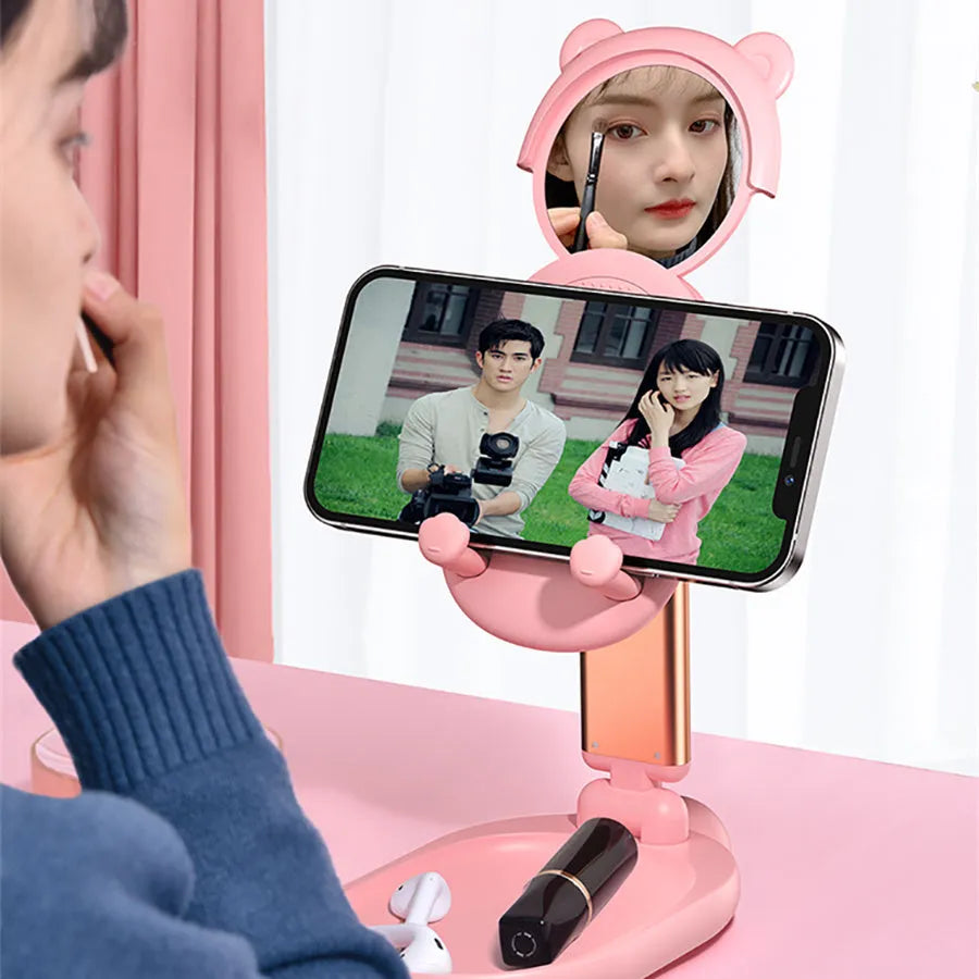 Blue adjustable aluminium and PC phone tablet stand with mirror on a wooden desk.