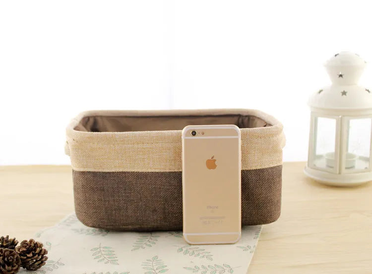 Blue foldable fabric storage basket shown next to folded clothes and a book.