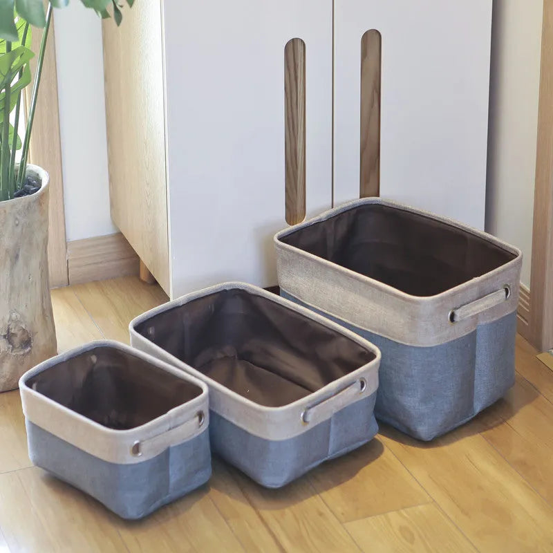 Blue foldable fabric storage basket shown next to folded clothes and a book.