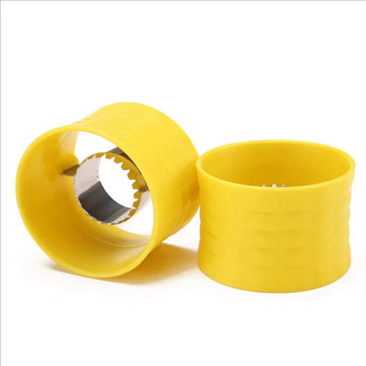 Yellow manual corn thresher with corn-kernel-shaped design on a kitchen counter.