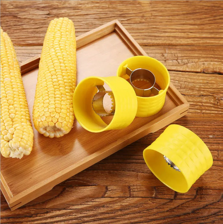 Yellow manual corn thresher with corn-kernel-shaped design on a kitchen counter.