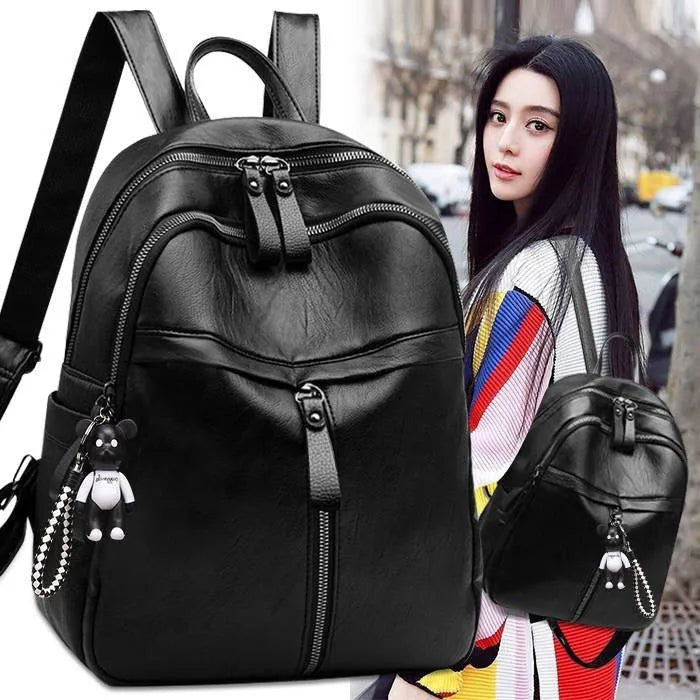 Black soft-surface PU leather backpack with double straps, shown with a pendant option.