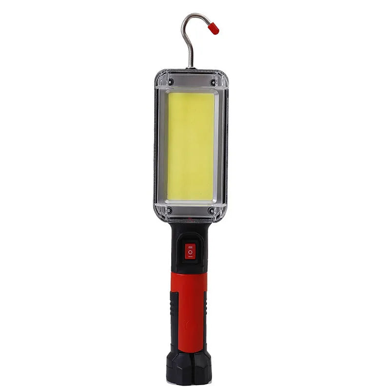 Red portable USB rechargeable COB camping lamp with magnetic hook on a metal surface.