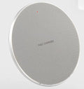 Round black wireless phone charger with aluminum base and Qi receiver on grey surface