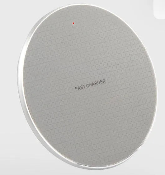 Round black wireless phone charger with aluminum base and Qi receiver on grey surface