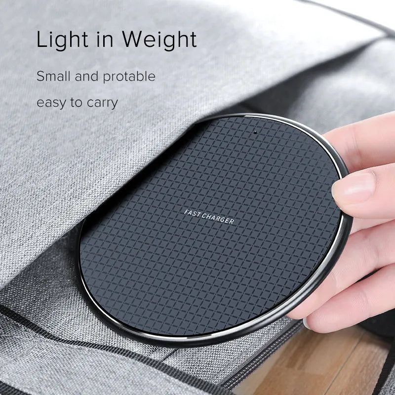 Round black wireless phone charger with aluminum base and Qi receiver on grey surface