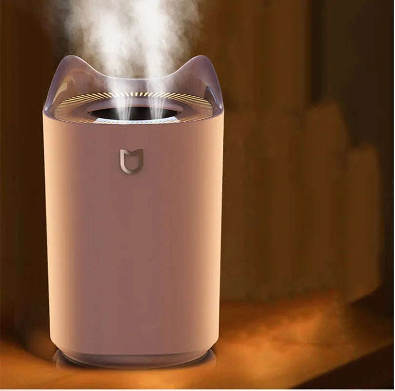 Coral pink double spray humidifier with large water tank and three mist outlets on a table.