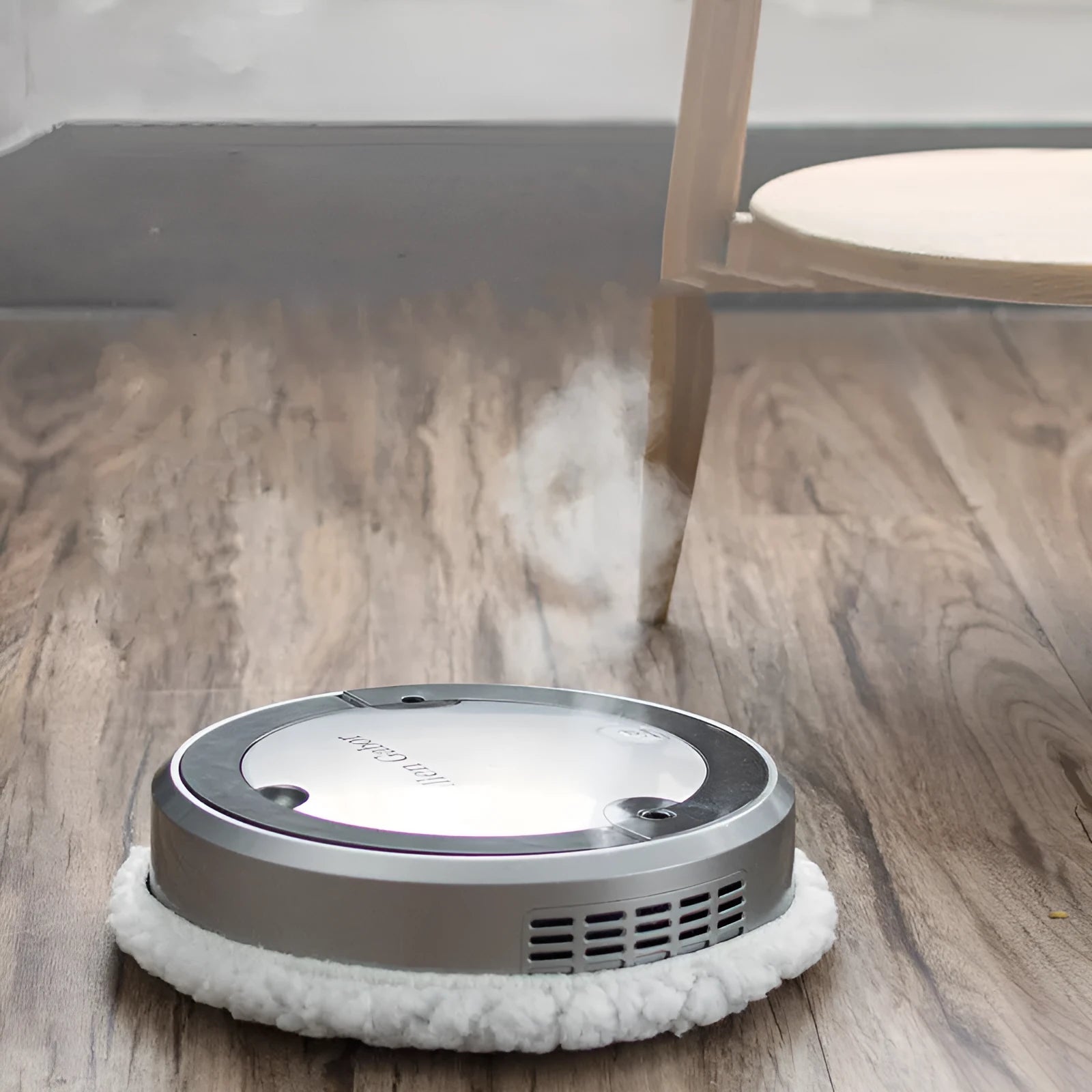 Intelligent automatic sweeping robot with spray and UV sterilisation in silver-gray on a hard floor