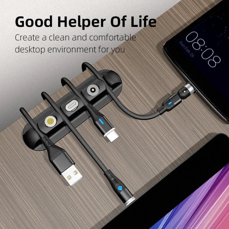 Black soft plastic desktop charging cable organiser on a wooden desk