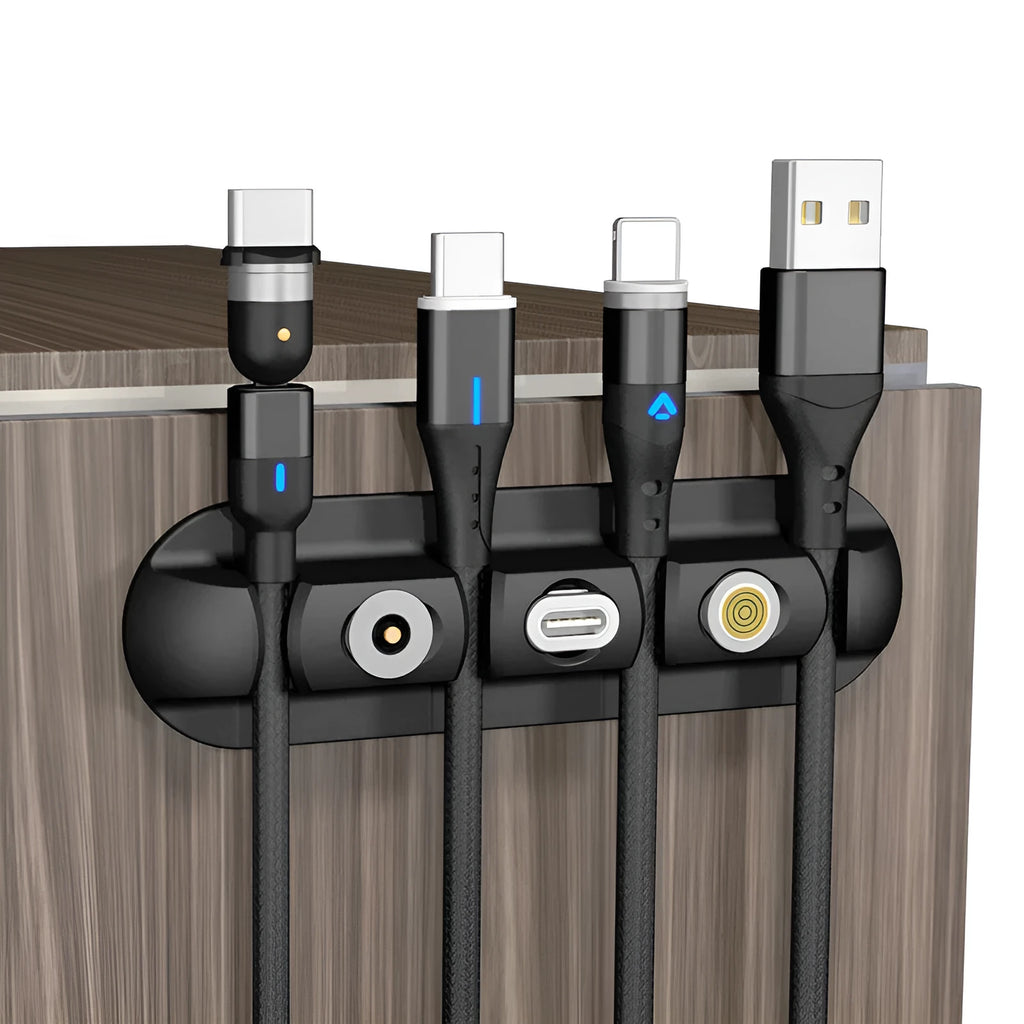 Black soft plastic desktop charging cable organiser on a wooden desk