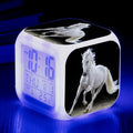 Small square cartoon-style alarm clock showing LED time display and available in multiple colours.