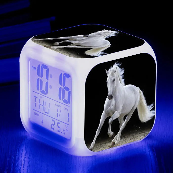 Small square cartoon-style alarm clock showing LED time display and available in multiple colours.