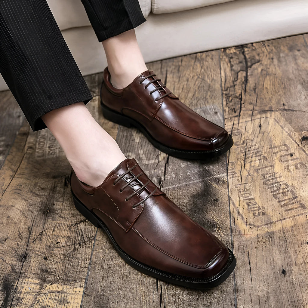 Men's black square toe business casual leather shoes with rubber sole on wooden background