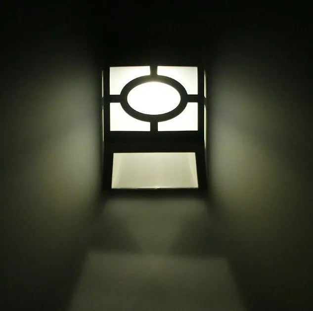Compact white plastic solar wall light with solar panel and LED light lens.