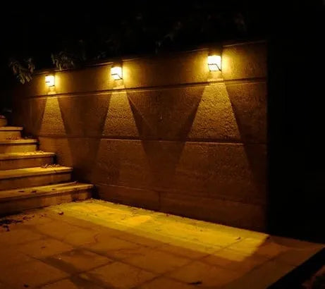 Compact white plastic solar wall light with solar panel and LED light lens.