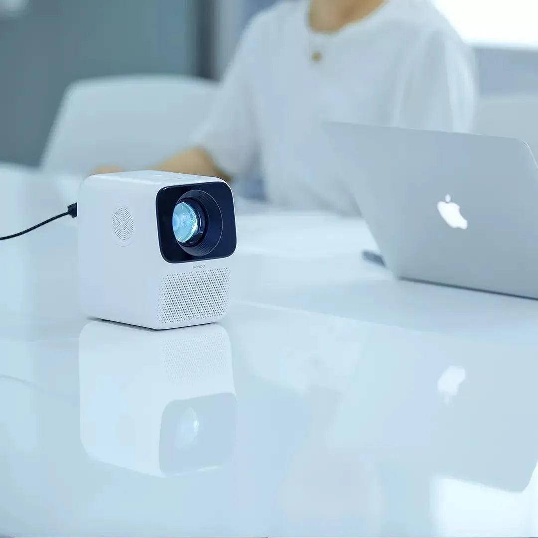 Xiaomi Wanbo T2max/Free compact white HD projector on a table with remote control