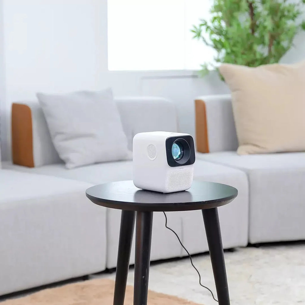 Xiaomi Wanbo T2max/Free compact white HD projector on a table with remote control