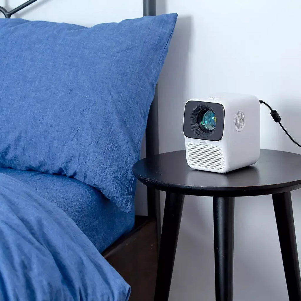 Xiaomi Wanbo T2max/Free compact white HD projector on a table with remote control