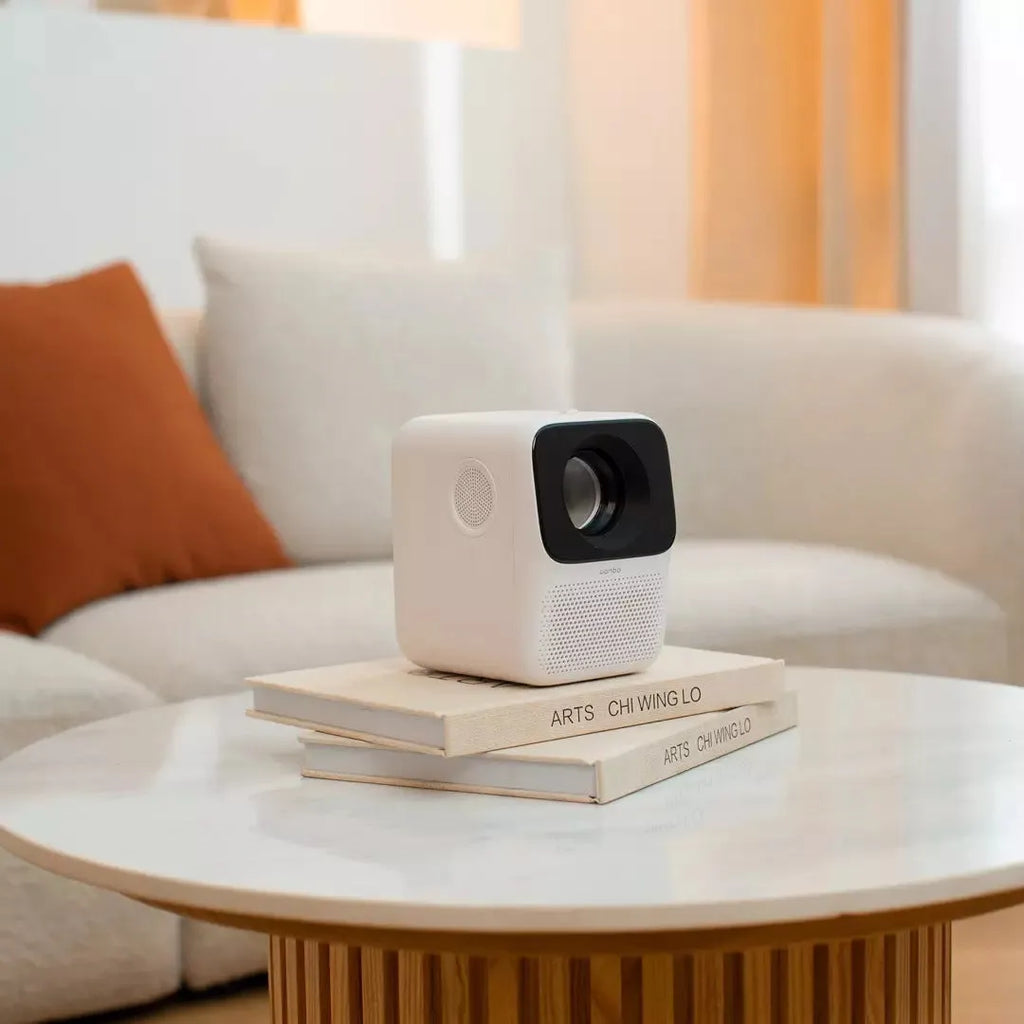 Xiaomi Wanbo T2max/Free compact white HD projector on a table with remote control