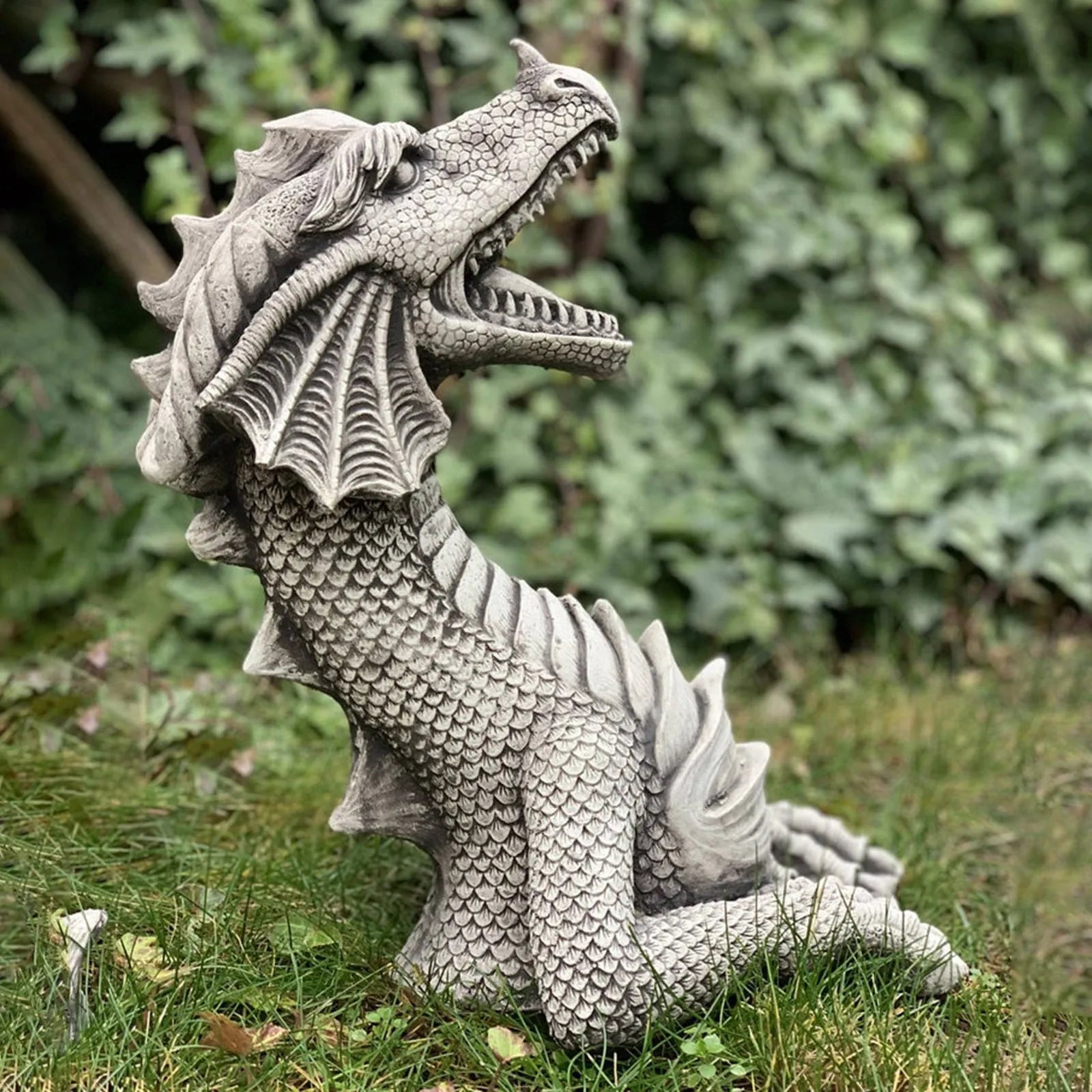 Large gothic dragon garden statue in charcoal grey resin with wings and tail, placed on a lawn