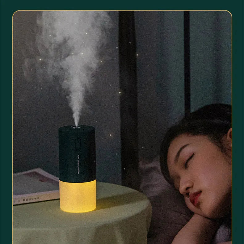 Blue columnar USB desktop humidifier with water tank and aromatherapy function on a wooden table.