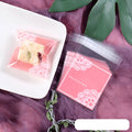 Pink self-adhesive plastic packaging bag showing adhesive strip and 7x7cm dimensions.