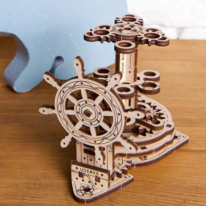 Wooden model of a rotating steering wheel that functions as a pen holder on a desk.