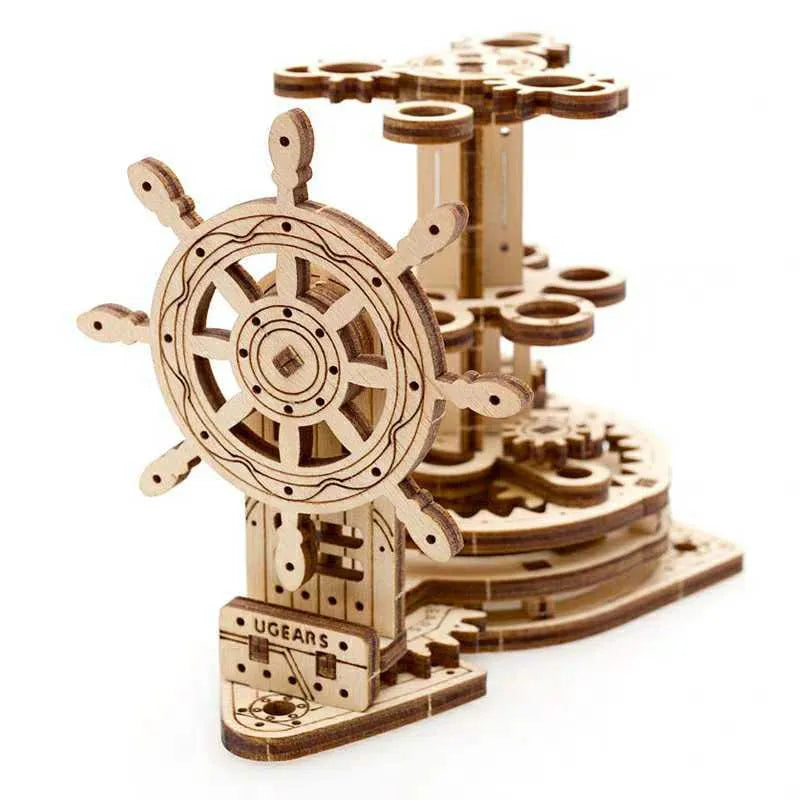 Wooden model of a rotating steering wheel that functions as a pen holder on a desk.