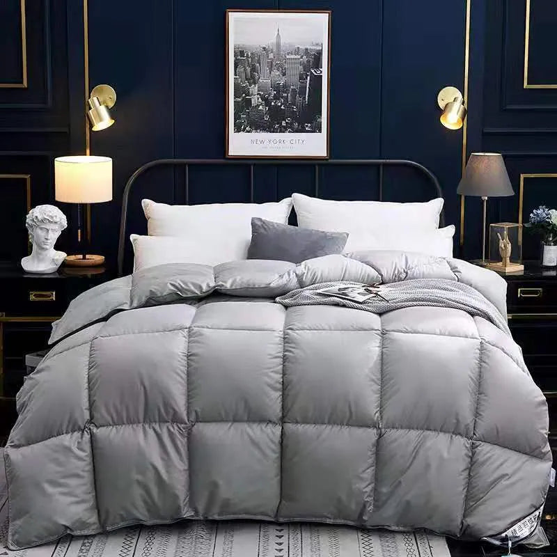 Goose down winter duvet in twill fabric, shown in beige colour on a bed.