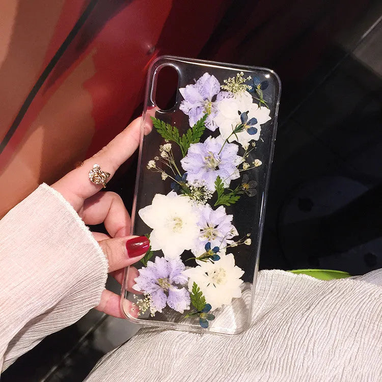 Soft blue and purple dried floral bouquet design on a transparent TPU case for an iPhone.