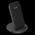 A white minimalist vertical wireless charging stand holding a smartphone upright on a desk.