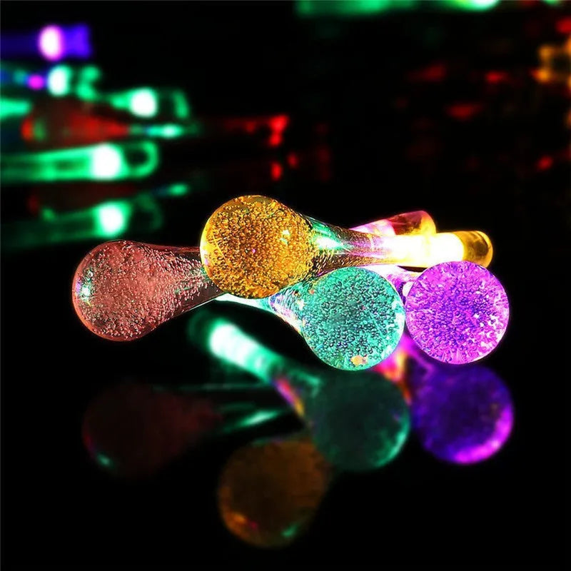 6.5 metre solar LED outdoor string lights with water drop bubble pendants in garden setting