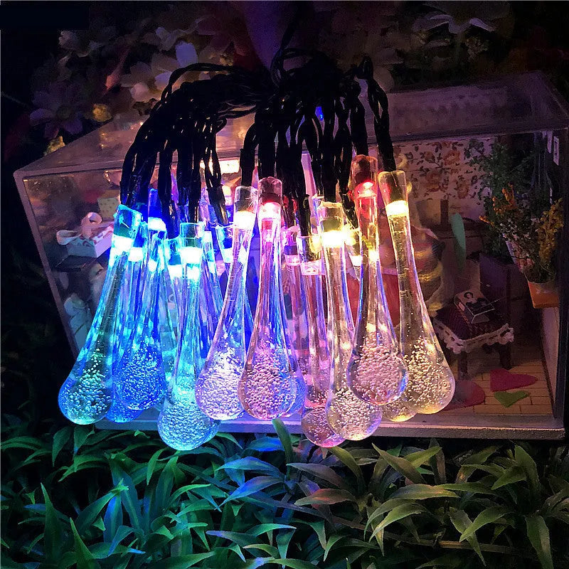 6.5 metre solar LED outdoor string lights with water drop bubble pendants in garden setting